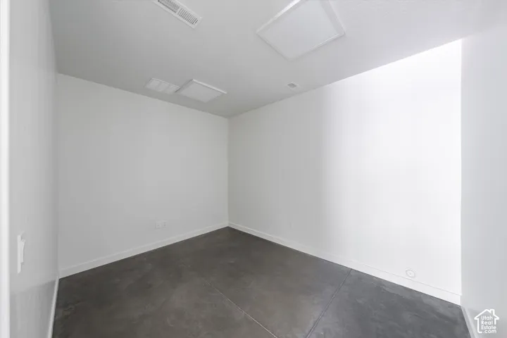 White walls with a concrete floor, featuring two square ceiling light fixtures