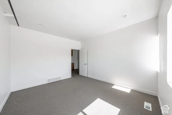 Carpeted room with recessed lighting and white walls