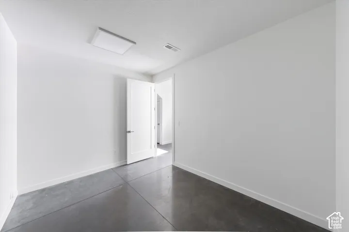 White walls with a square ceiling light and dark floor