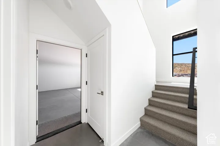 Staircase with carpeted treads and a metal railing