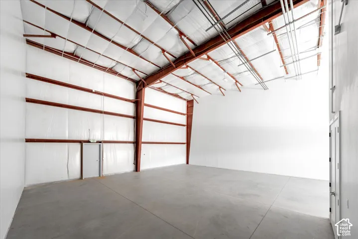 Exposed ceiling rafters, industrial-style metal framing, insulated wall panels, concrete flooring, and multiple access doors