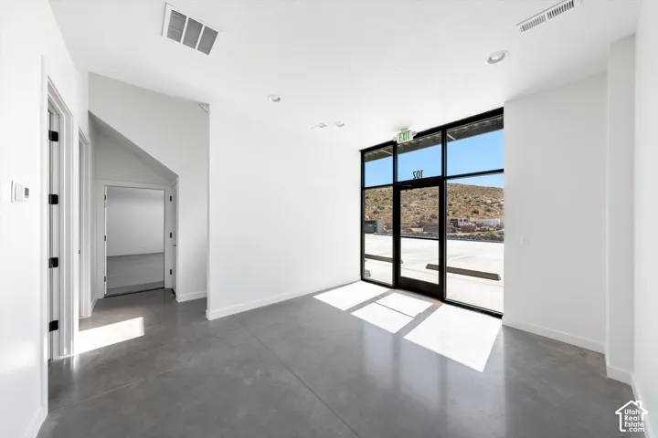 Expansive storefront windows, concrete flooring, recessed lighting, and a white ceiling finish