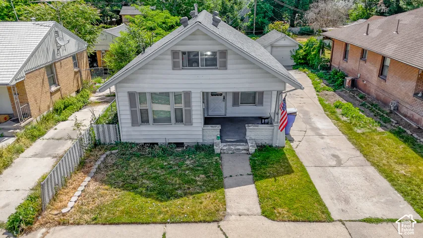 Classic front-facing elevation featuring a gabled roofline, horizontal siding exterior, multi-pane windows, and a covered front porch with concrete steps