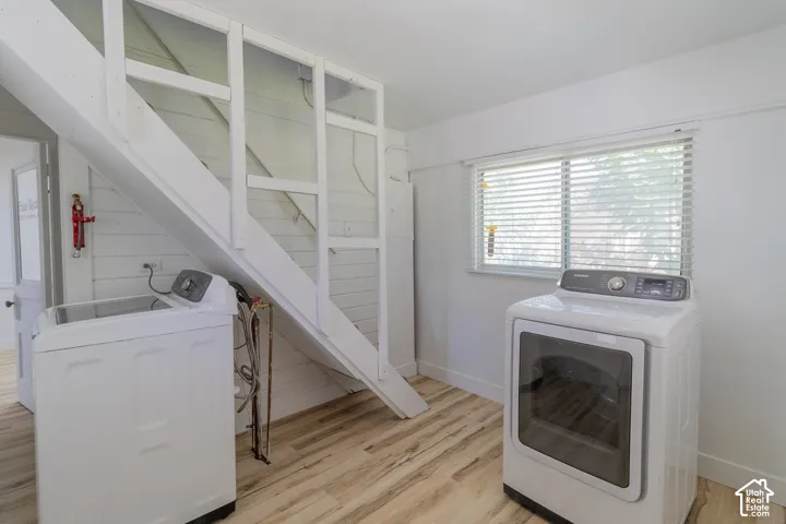 Wood-finish flooring with white walls and a window featuring blinds