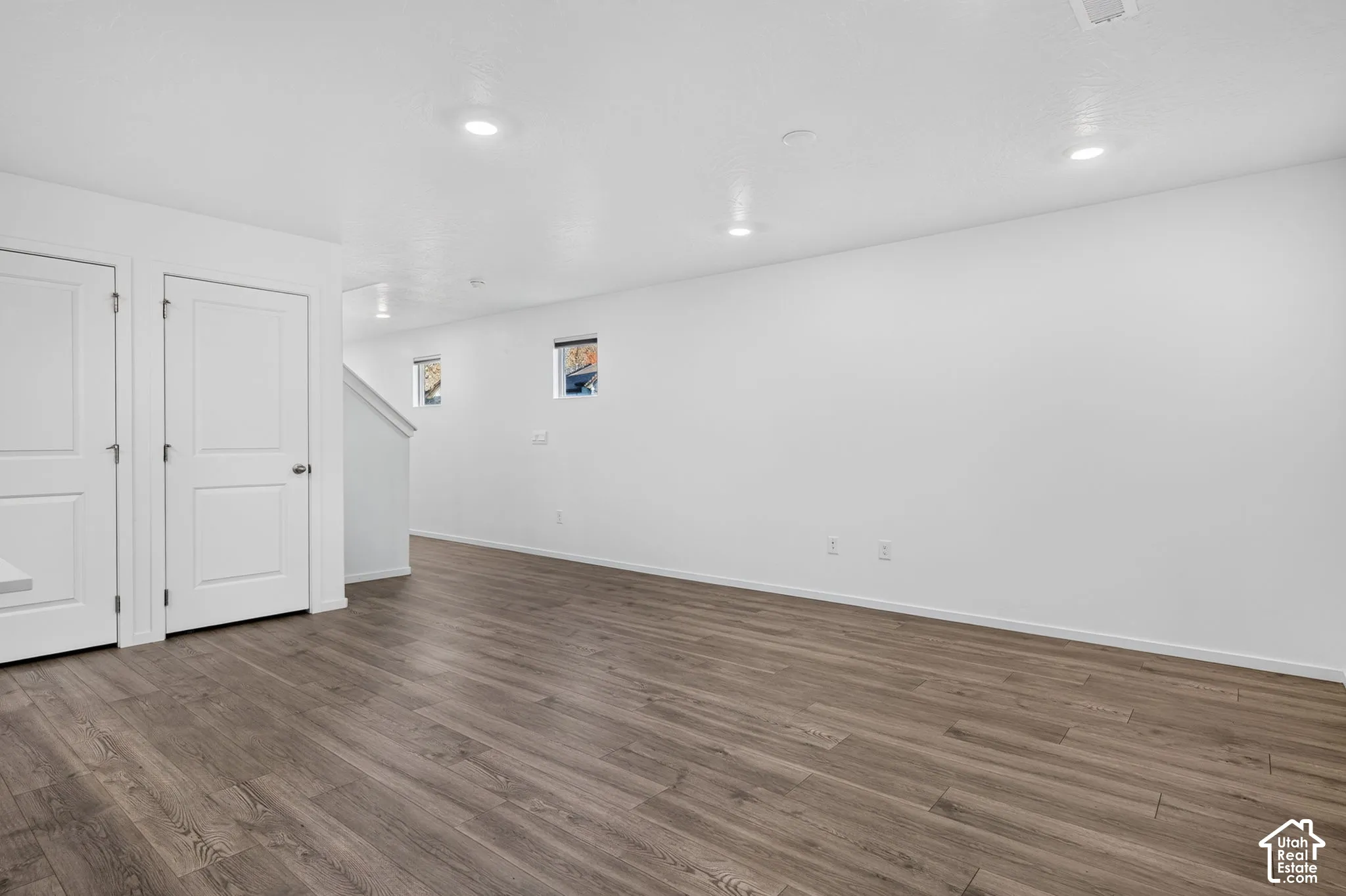 Recessed ceiling lighting, wood-finish flooring, white walls, and white trim molding