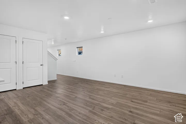 Recessed ceiling lighting, wood-finish flooring, white walls, and white trim molding