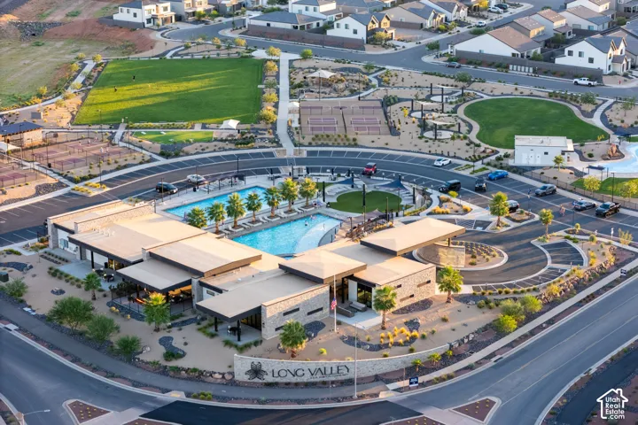 Community clubhouse with multiple swimming pools, tennis courts, and landscaped green spaces