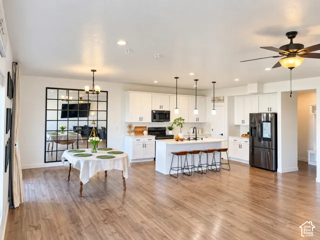Open-concept living space with wood-finish flooring, recessed lighting, and a ceiling fan
