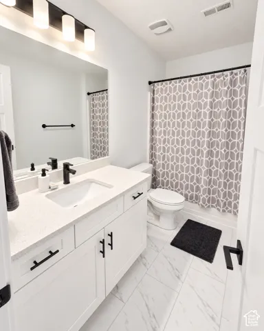 White vanity with a light-toned countertop and an undermount sink