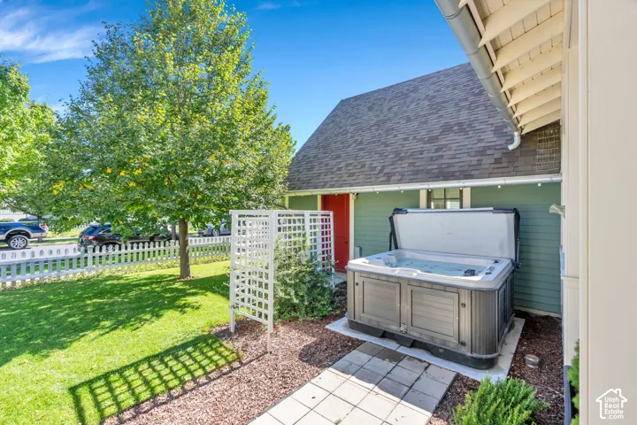 Hot tub situated on a concrete pad, surrounded by decorative rock and stepping stones