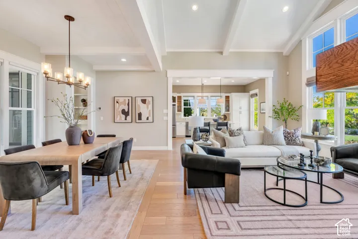 Open-concept living space featuring wood-finish flooring, exposed beam ceiling, built-in shelving, and transom windows