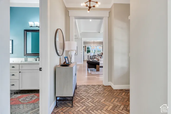 Herringbone pattern brick flooring, arched entryway, and overhead chandelier