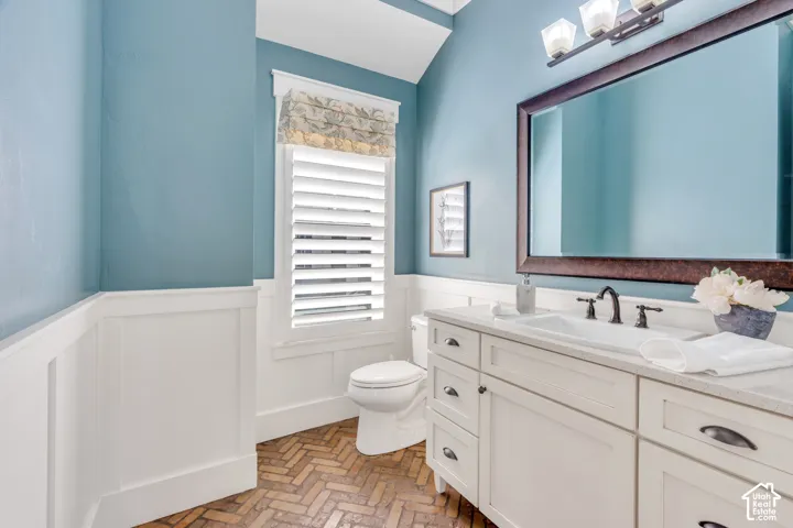 White vanity with integrated sink, bronze-finish faucet, and coordinating mirror