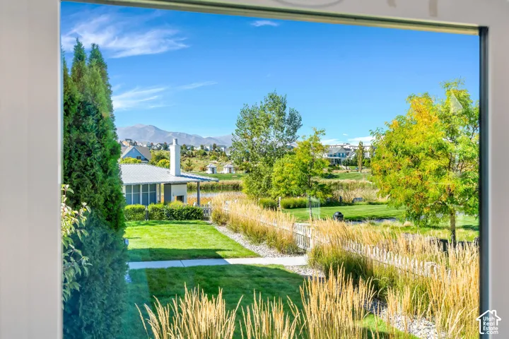 Expansive outdoor area featuring a manicured lawn, surrounding greenery, and a distant mountain range backdrop