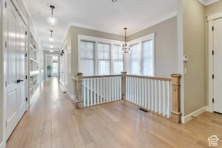 Expansive wood-finish flooring throughout, featuring a staircase with wood newel posts and white balusters