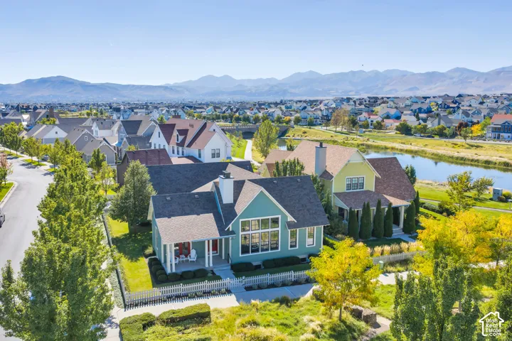 Expansive residential area featuring diverse architectural styles, a prominent waterway, and distant mountain ranges