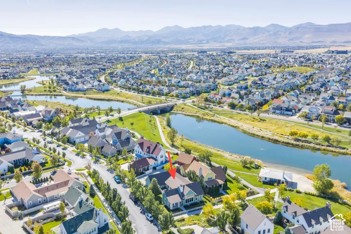 Aerial community perspective with a waterway, residential properties, and distant mountains