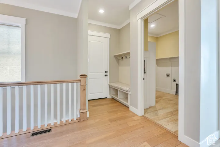 Hardwood-style flooring throughout, built-in mudroom bench with coat hooks, upper shelving, and recessed lighting