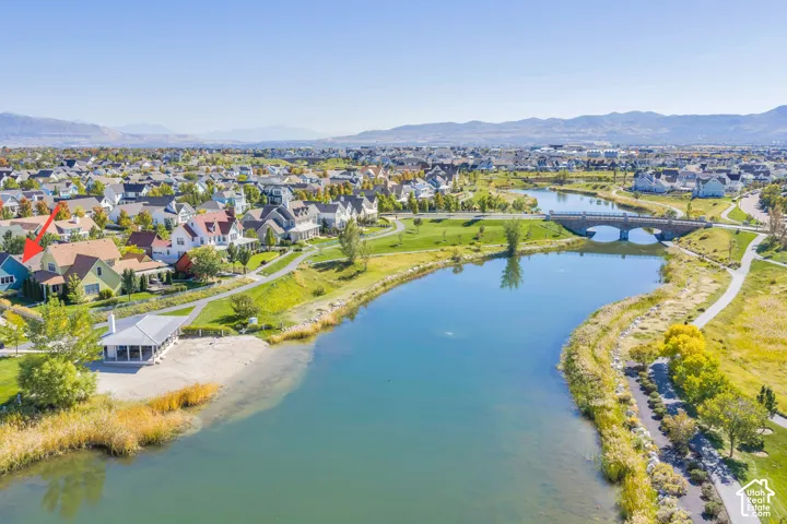 Community featuring a serene waterway, pedestrian pathways, and a stone arch bridge
