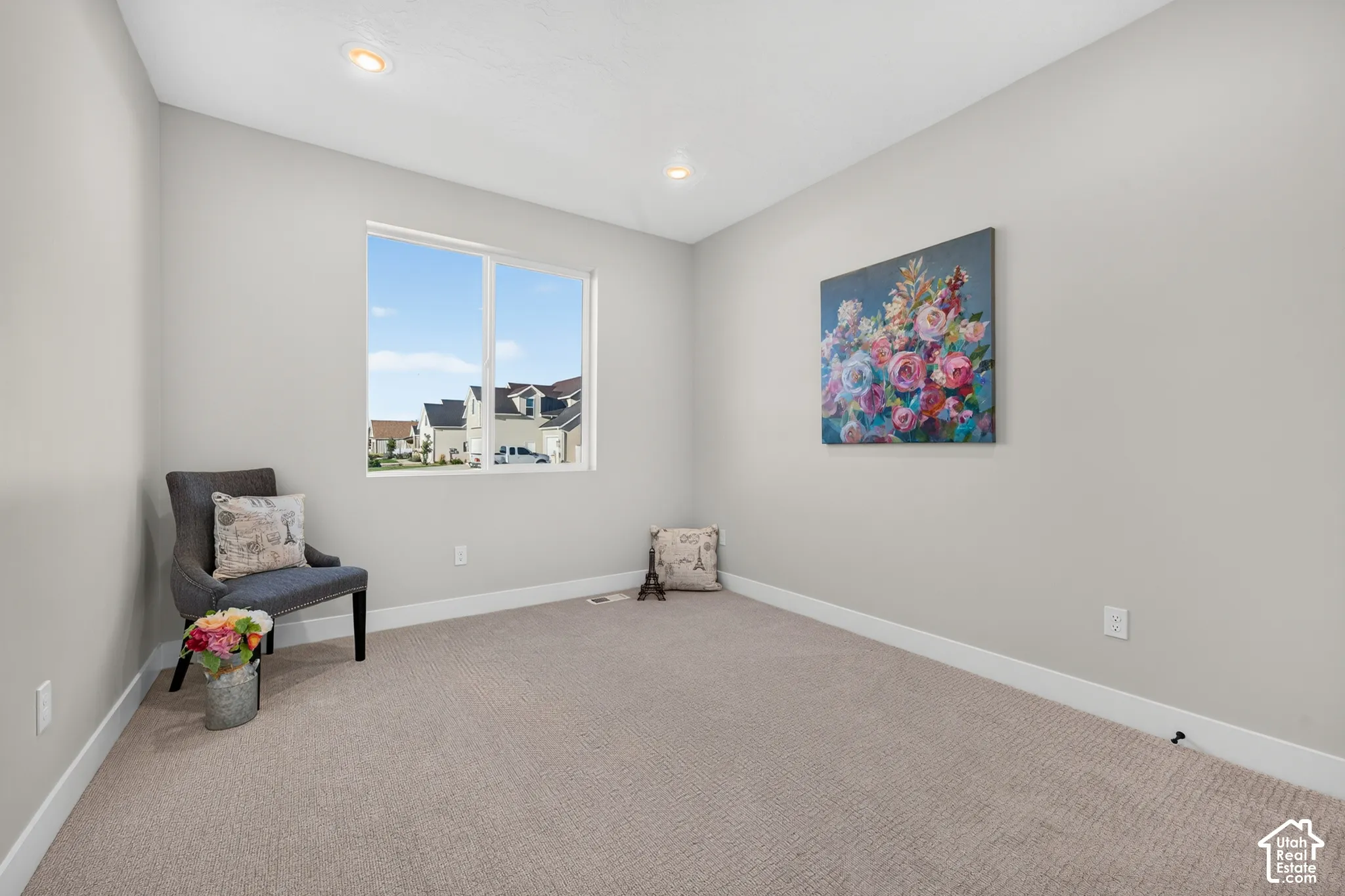 Recessed ceiling lighting, neutral wall paint, white trim, light-colored carpeting, and a window with white framing