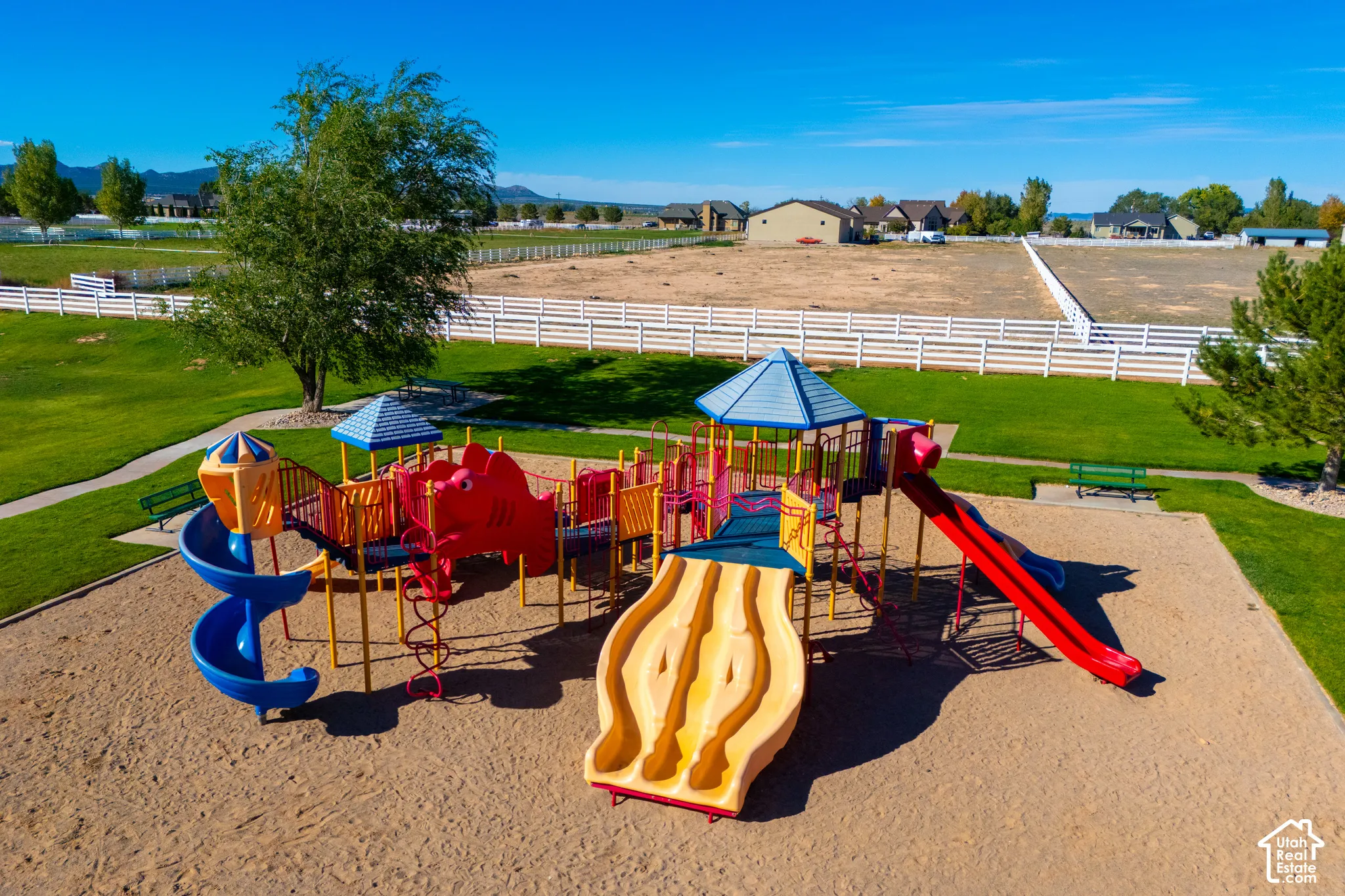 Community playground featuring multiple slides, climbing elements, and sand ground cover