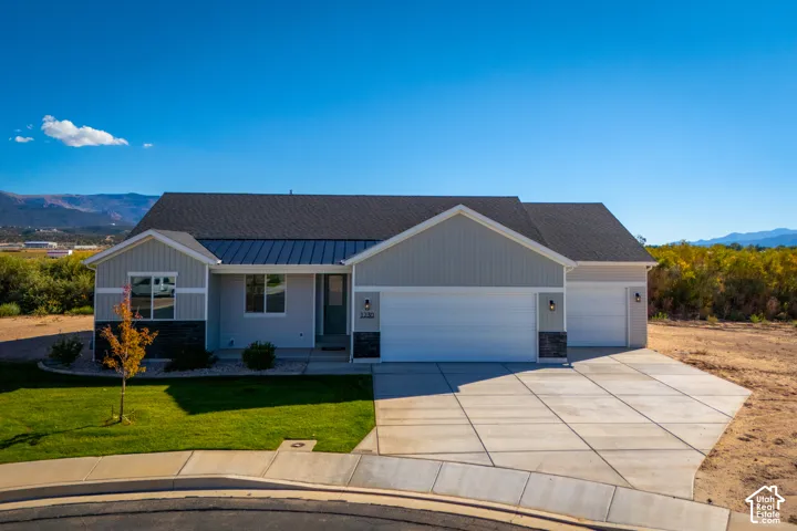 Contemporary ranch-style residence featuring a combination of horizontal siding and stone veneer, a dark shingle roof, and a metal accent roof