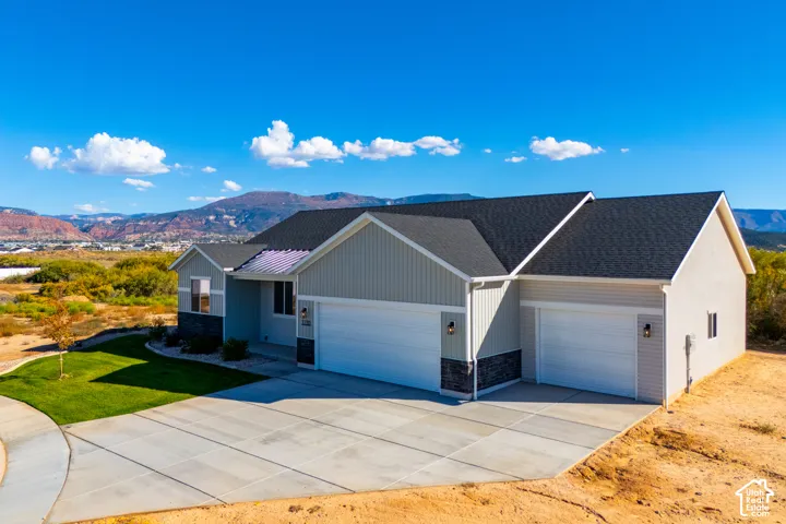 Contemporary single-story residence with a multi-car garage, partial stone fa