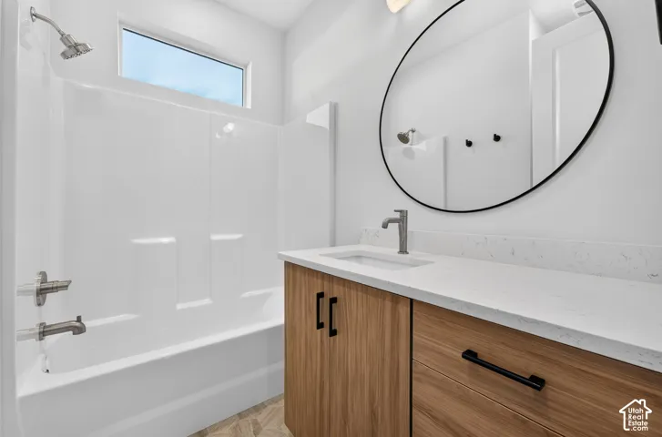 Wood-finish vanity with a light-toned countertop, undermount sink, and brushed nickel faucet