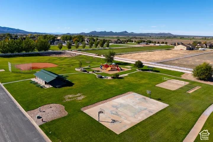 Expansive park space featuring a baseball field, children's play area, covered picnic pavilion, basketball court, and sand volleyball court
