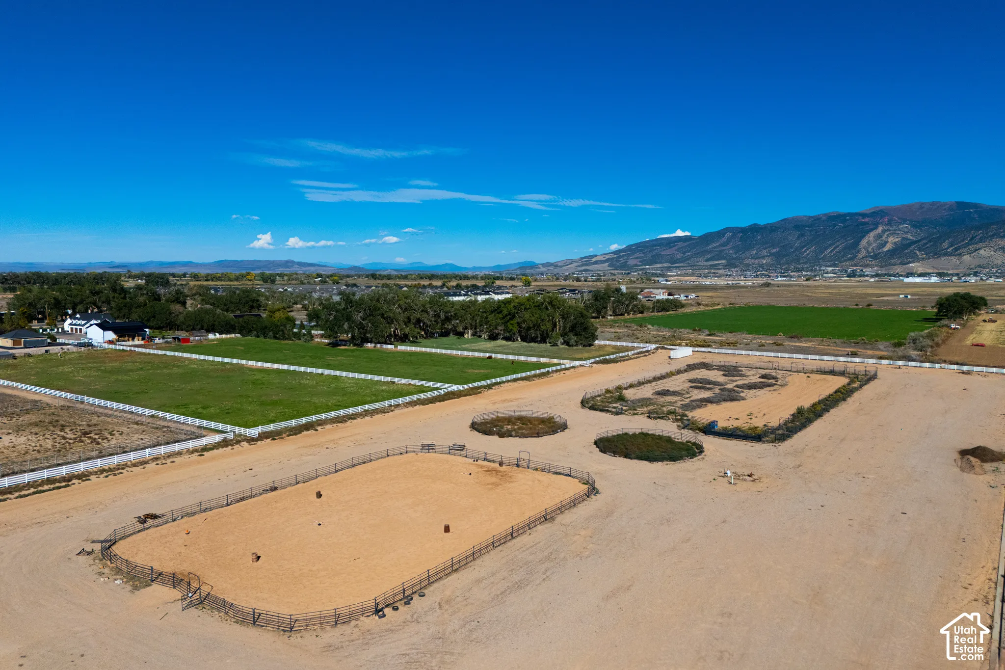 Expansive property featuring multiple fenced paddocks, a large riding arena, and substantial land parcels