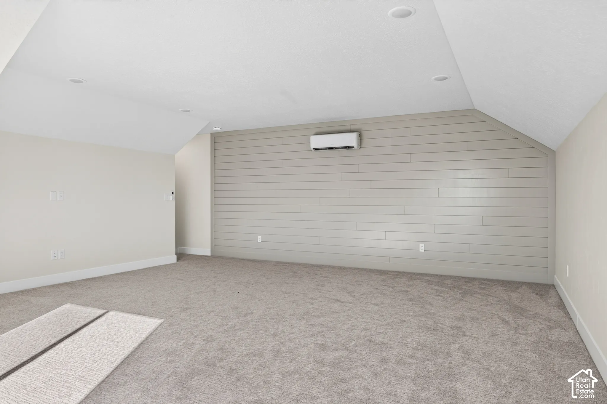 Carpeted flooring, recessed lighting, and a wall-mounted climate control unit