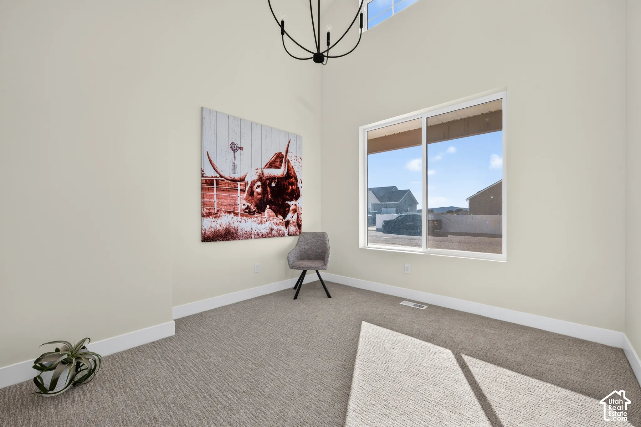Carpeted room with high ceilings, recessed lighting, and a large sliding window