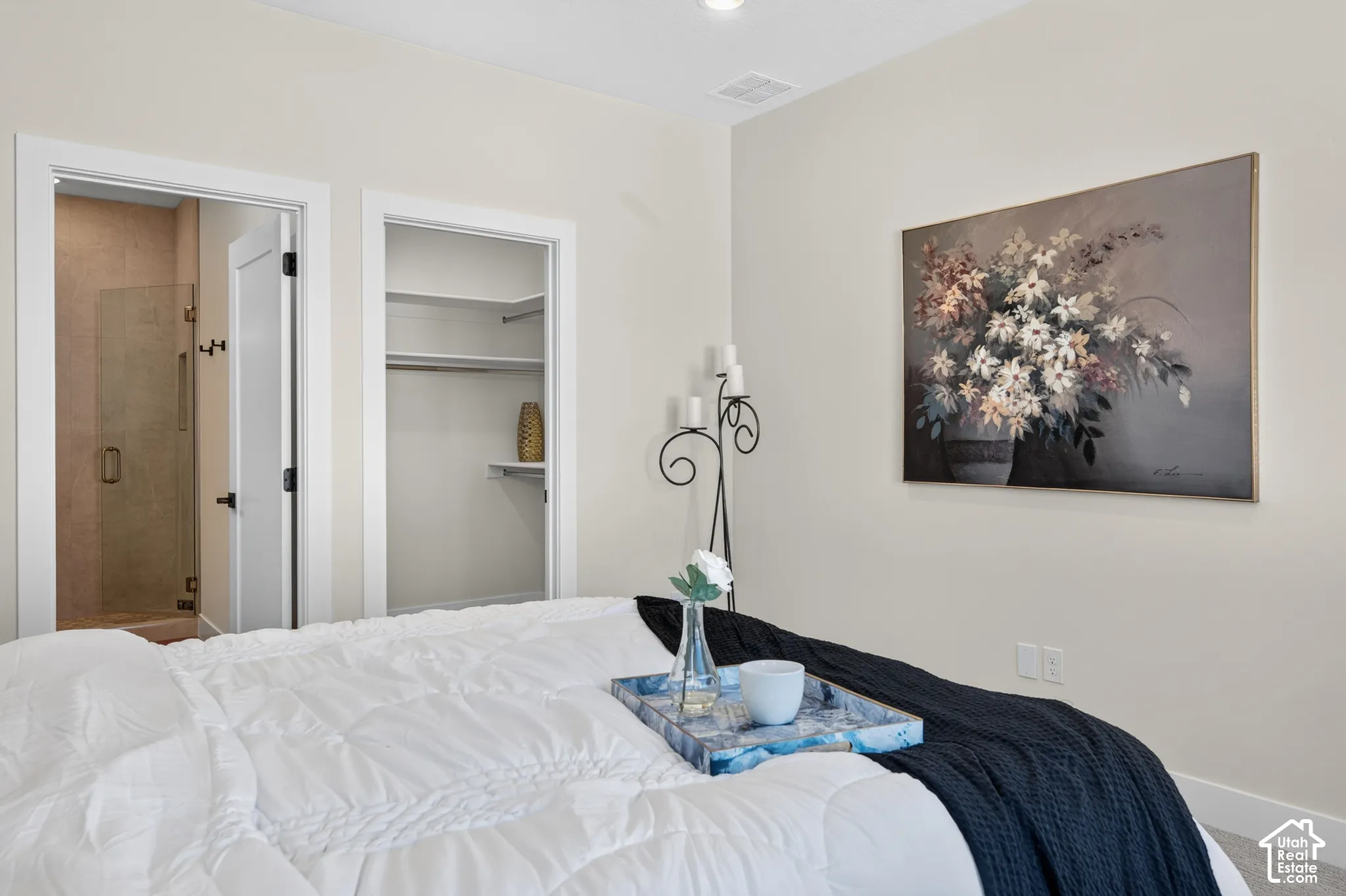 Neutral wall color, built-in closet shelving, and a glass-enclosed shower