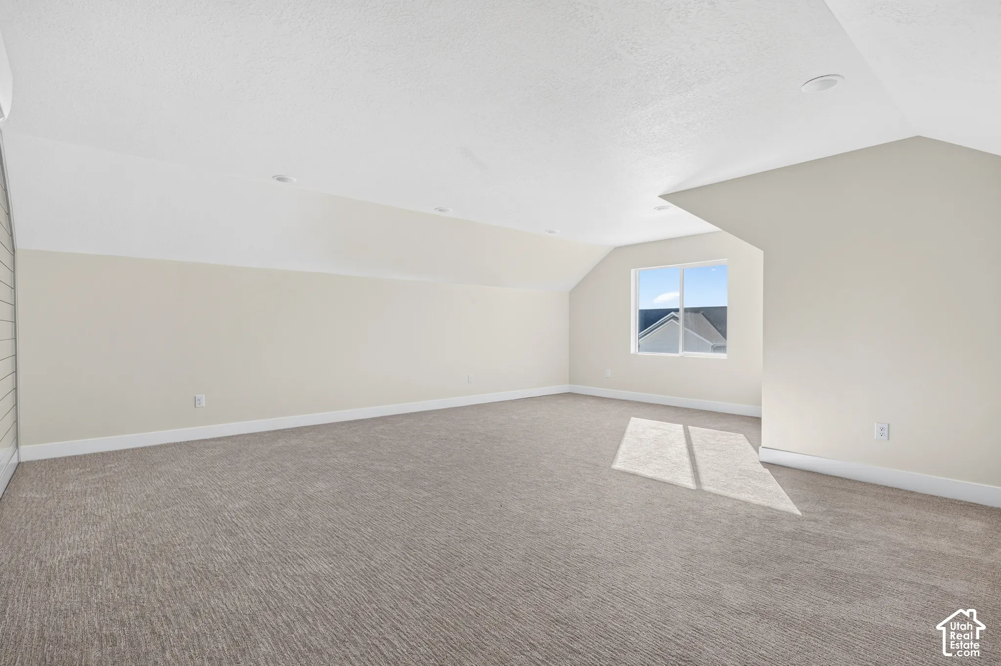 Spacious room featuring carpeting, recessed lighting, and a window with exterior views