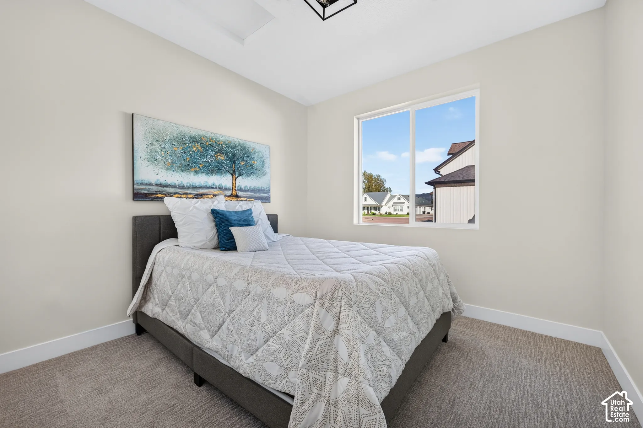 Carpeted flooring, neutral wall tones, large window, tray ceiling with recessed lighting, and a modern ceiling fixture
