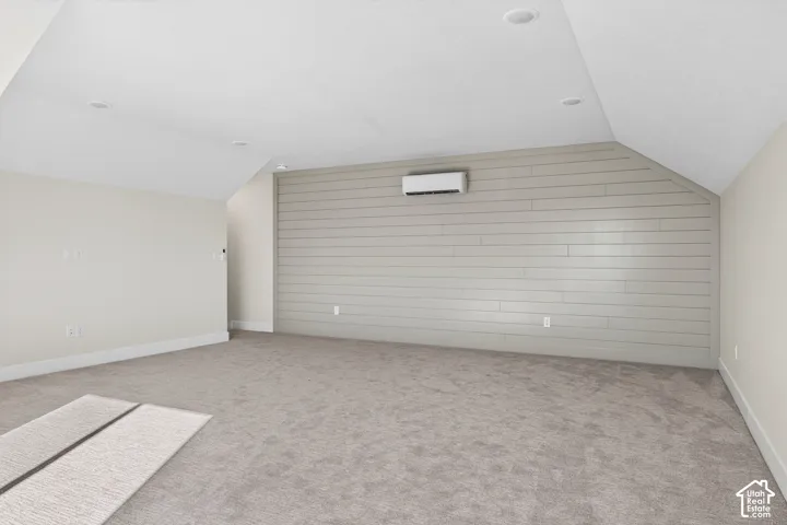 Carpeted flooring, recessed lighting, and a wall-mounted climate control unit