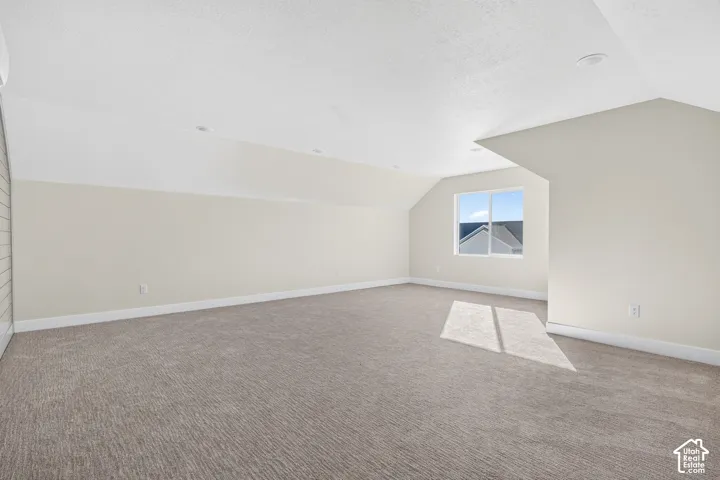Spacious room featuring carpeting, recessed lighting, and a window with exterior views