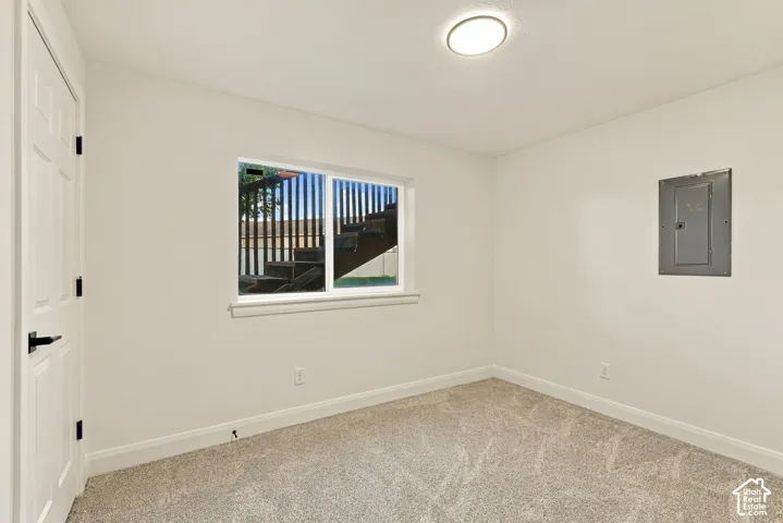 Carpeted flooring, white walls, and a multi-pane window