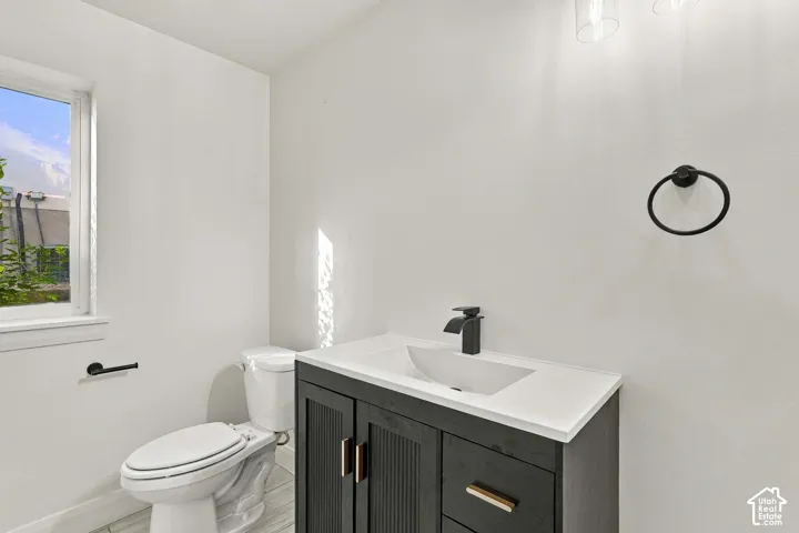 Dark wood-finish vanity with integrated sink, matte black faucet, and brass-tone hardware
