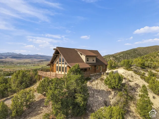 Wood-sided residence with a brown shingled roof, a multi-level deck, and a prominent A-frame window design
