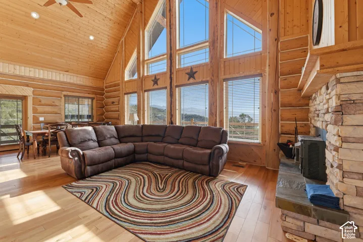 Vaulted wood-paneled ceilings, natural wood-finish flooring, and a stone-clad fireplace