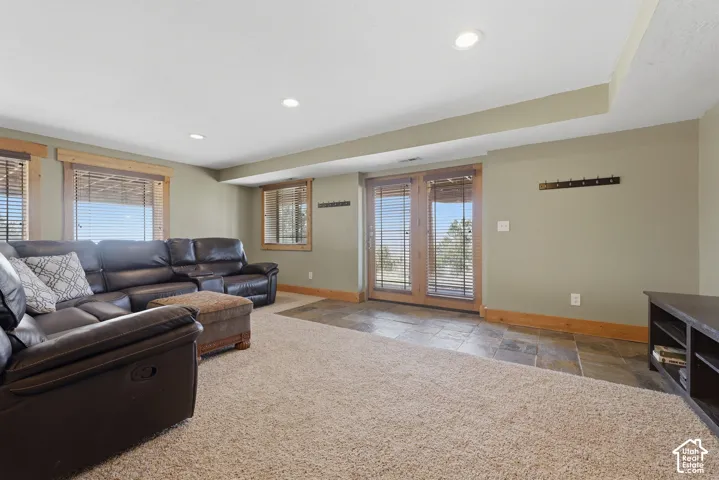 Recessed lighting, wood-trim windows, and a carpeted floor