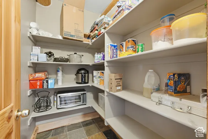 Built-in shelving for organized storage, durable slate-style flooring, and a natural wood-finish door