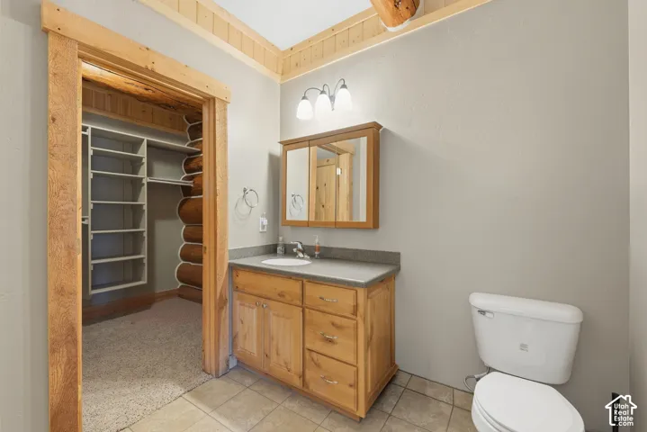 Wood-finish vanity with a single basin sink and gray countertop