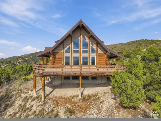A-frame log exterior with a multi-level deck, expansive windows, and a brown shingle roof