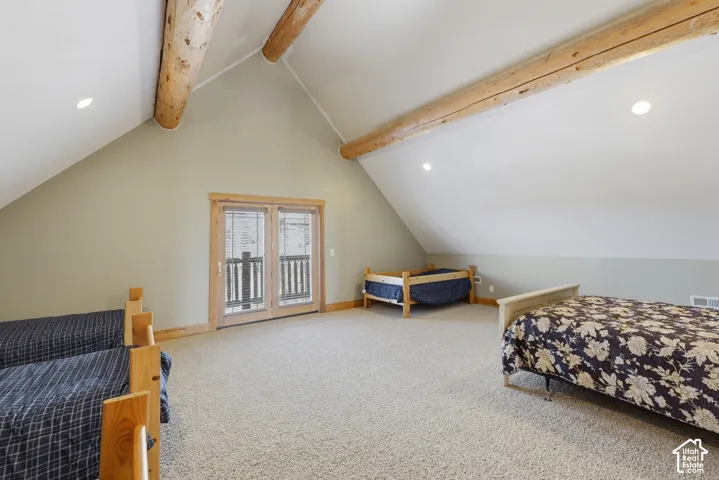 Vaulted ceiling with exposed wood beams, recessed lighting, double French doors, and wall-to-wall carpeting