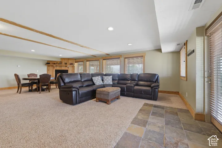 Spacious area featuring recessed lighting, a fireplace with a wood mantel, and multiple windows with wood trim