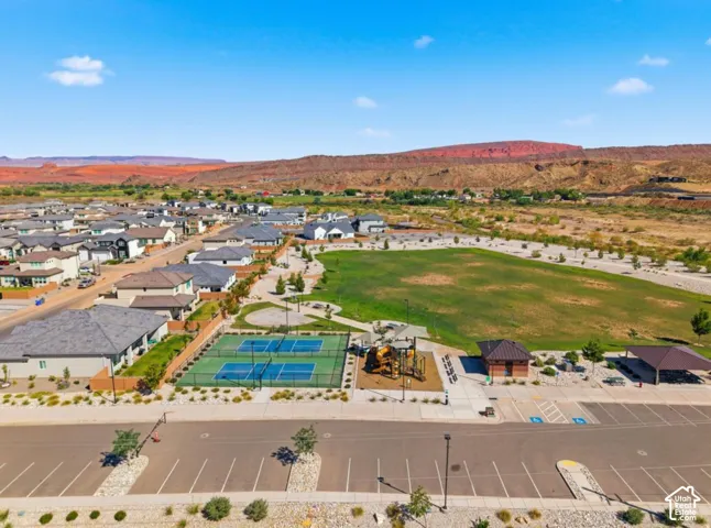Community green space with a playground, tennis courts, and covered picnic areas