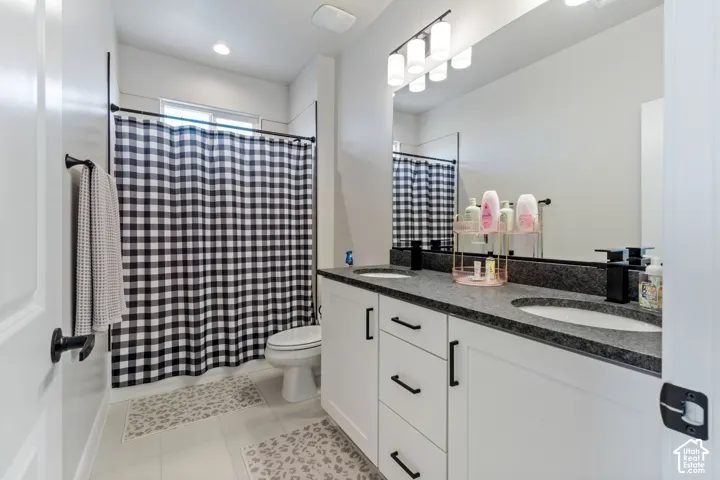 Dual vanity with dark stone countertops, two undermount sinks, and matte black fixtures