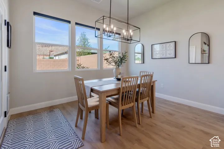 Wood-finish flooring, multiple windows, rectangular chandelier, light-toned walls